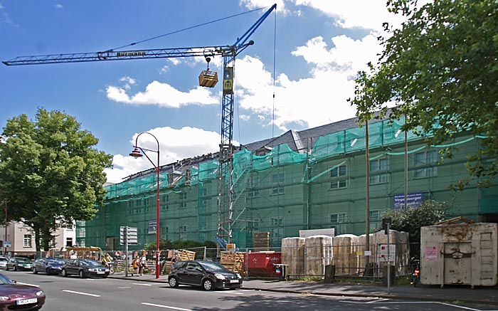 Baugerüst, Kran vor langem Gebäude
